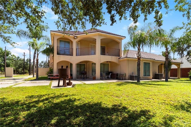 6614 Mile 7 Rd, Mission, TX 78573 - back of house featuring a balcony, stucco siding, a yard, cooling unit, and a patio
