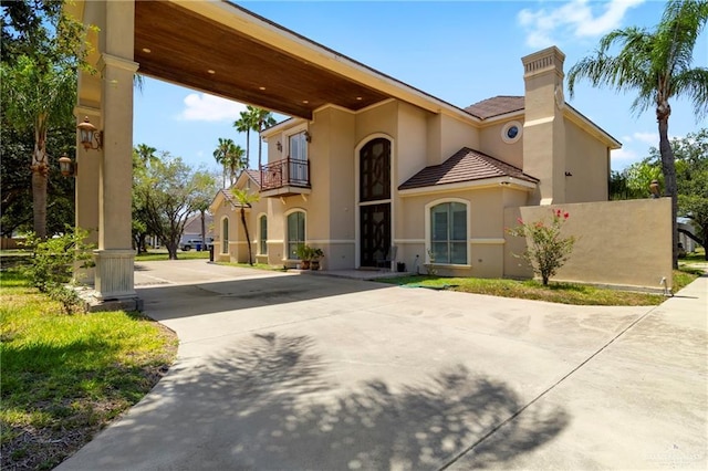 6614 Mile 7 Rd, Mission, TX 78573 - view of front of house with a balcony, a chimney, stucco siding, driveway, and a tile roof