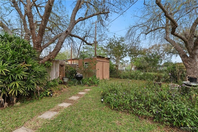 view of yard with a storage unit, an outbuilding, and a fenced backyard