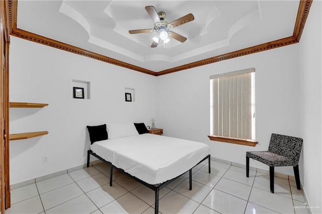 tiled bedroom featuring ceiling fan and a tray ceiling