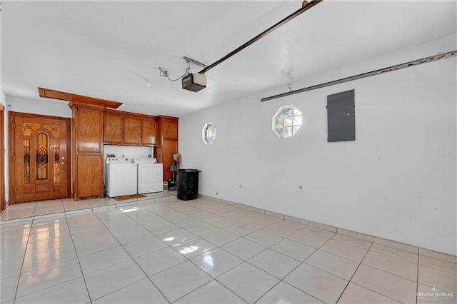 garage featuring electric panel, washer and clothes dryer, and a garage door opener