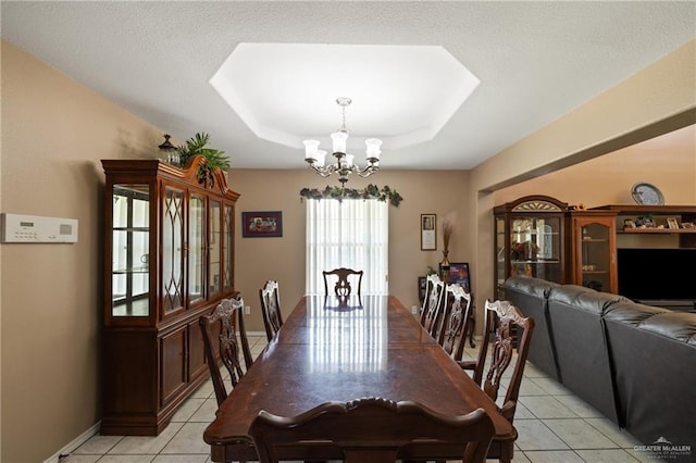 2315 E Sprague St, Edinburg, TX 78542 - dining space with a tray ceiling, a chandelier, baseboards, and light tile patterned flooring