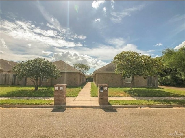 view of front of house with fence and a front lawn