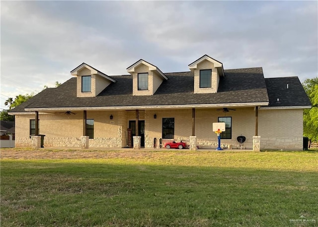 rear view of house featuring ceiling fan and a yard