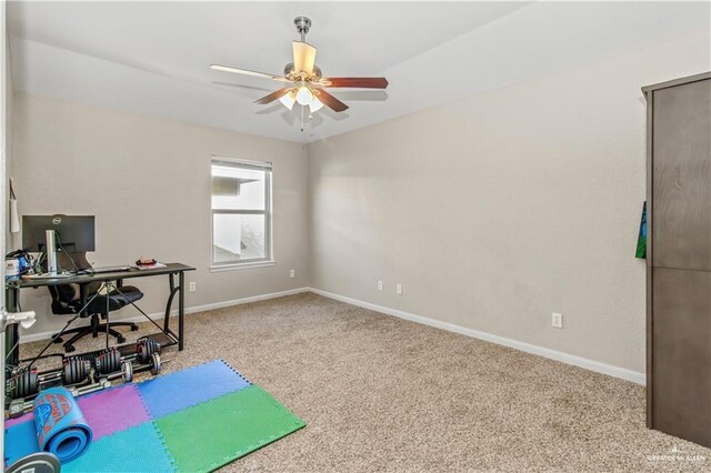 carpeted office space featuring ceiling fan