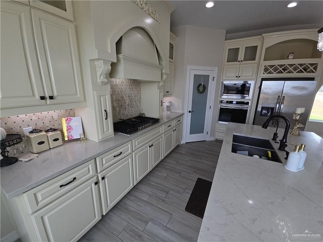 kitchen featuring sink, light hardwood / wood-style flooring, light stone counters, white cabinetry, and stainless steel appliances