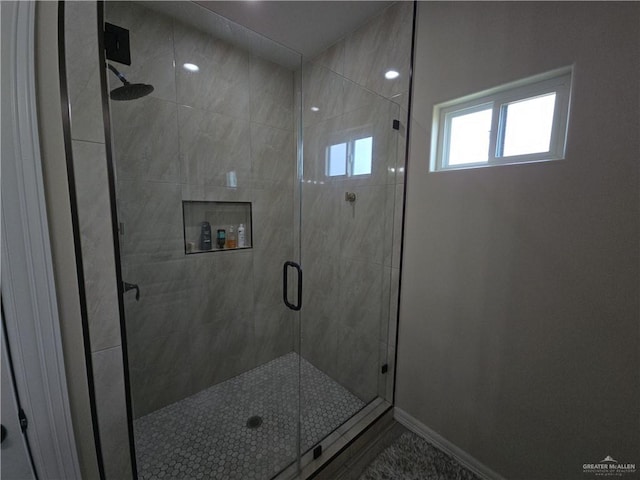 bathroom featuring a shower with door