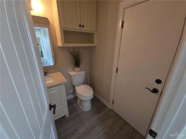 bathroom with hardwood / wood-style floors, vanity, and toilet