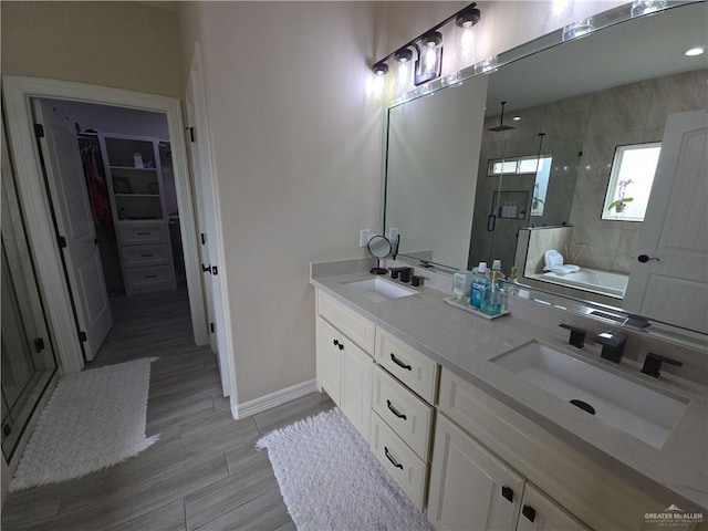 bathroom with hardwood / wood-style floors, vanity, and plus walk in shower