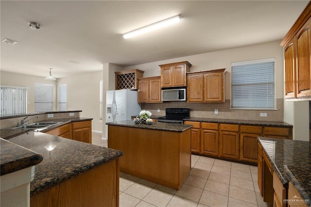 kitchen with black range with electric cooktop, sink, a kitchen island, white fridge with ice dispenser, and light tile patterned flooring