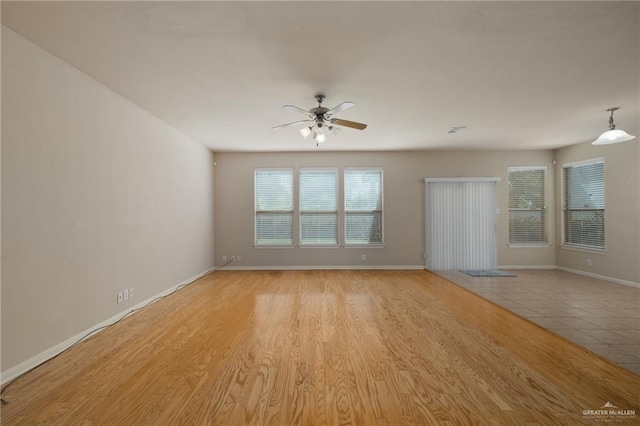 empty room with ceiling fan and light wood-type flooring