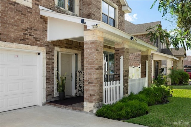 view of exterior entry featuring a yard and a garage