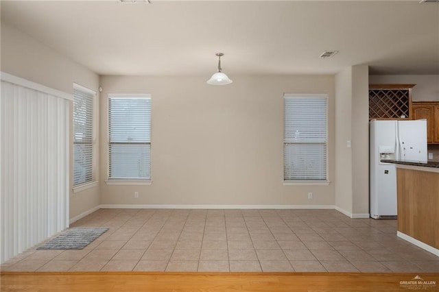 unfurnished dining area featuring light tile patterned floors