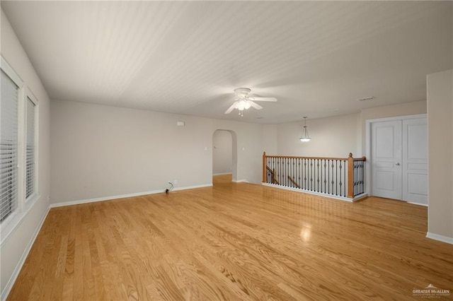 empty room with ceiling fan and light hardwood / wood-style flooring