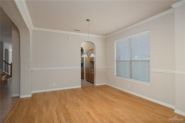 unfurnished dining area featuring hardwood / wood-style flooring, crown molding, and a notable chandelier