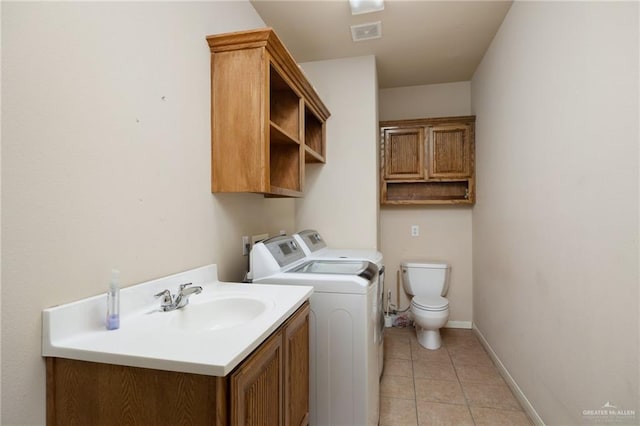 washroom featuring independent washer and dryer, light tile patterned floors, and sink