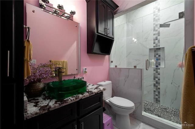 bathroom featuring tile patterned flooring, vanity, toilet, and a shower with door