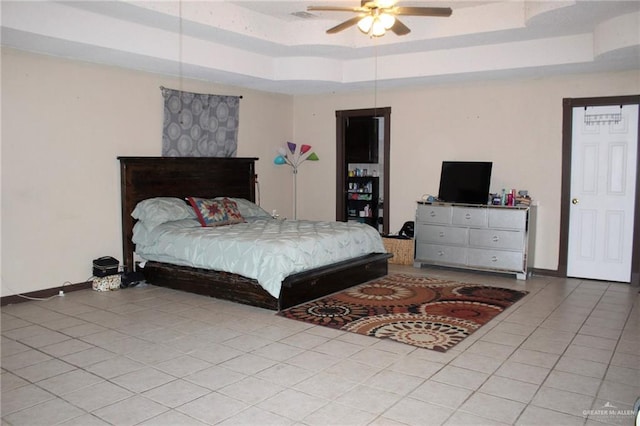 tiled bedroom featuring ceiling fan and a raised ceiling