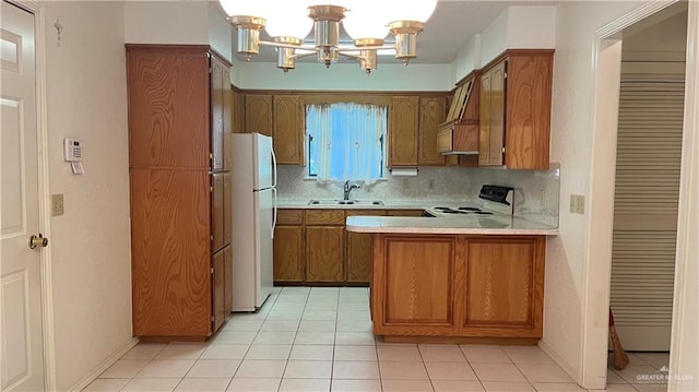 kitchen featuring sink, tasteful backsplash, kitchen peninsula, a chandelier, and white appliances