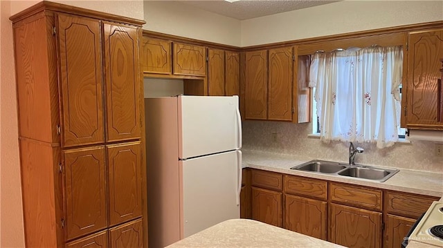 803 E Los Torritos St, Weslaco, TX 78596 - kitchen with freestanding refrigerator, brown cabinetry, and light countertops