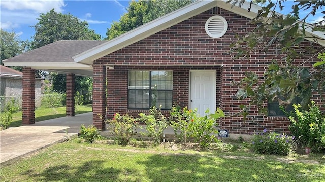 803 E Los Torritos St, Weslaco, TX 78596 - view of front of home featuring brick siding, a front lawn, and an attached carport