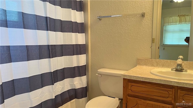 bathroom featuring vanity, a shower with shower curtain, and toilet