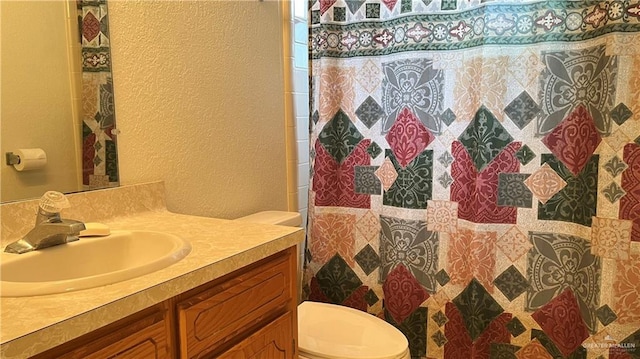 bathroom featuring a shower with shower curtain, vanity, and toilet