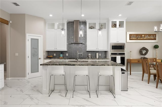 kitchen with marble finish floor, visible vents, wall chimney exhaust hood, and appliances with stainless steel finishes
