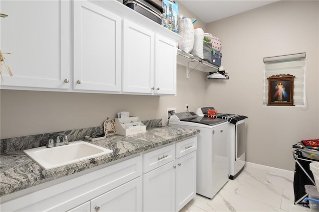 laundry area with baseboards, separate washer and dryer, marble finish floor, a sink, and cabinet space