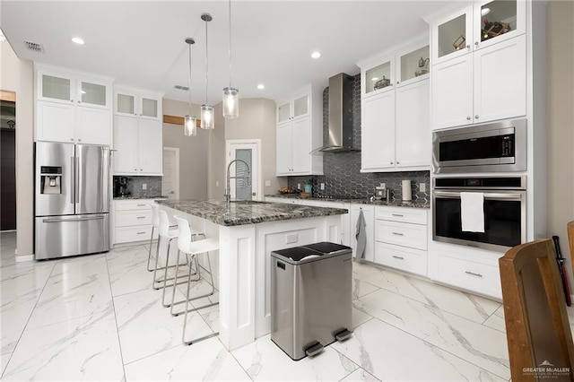 kitchen featuring stainless steel appliances, backsplash, marble finish floor, visible vents, and wall chimney range hood