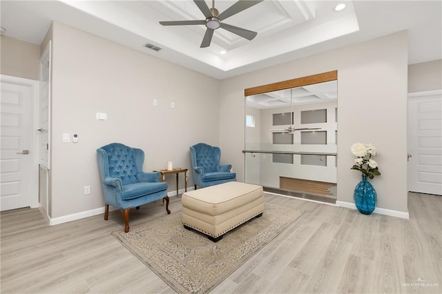 sitting room featuring a ceiling fan, baseboards, and light wood-type flooring