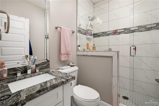bathroom with toilet, vanity, and a shower stall