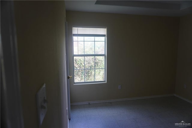 empty room featuring baseboards and tile patterned floors