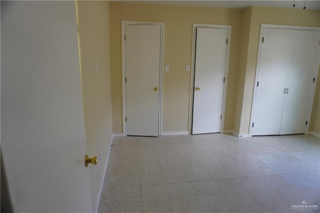 unfurnished bedroom featuring tile patterned floors and baseboards