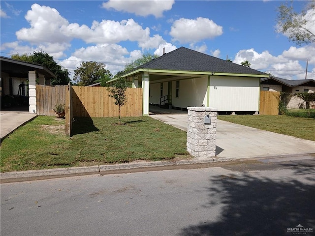 view of front of home with an attached carport, fence, a front lawn, and concrete driveway