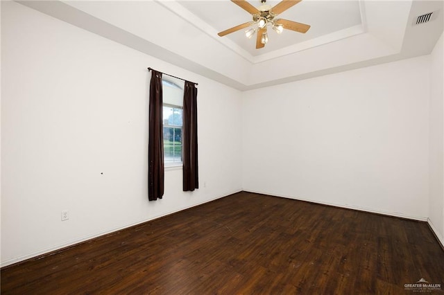 spare room featuring hardwood / wood-style floors, a tray ceiling, and ceiling fan