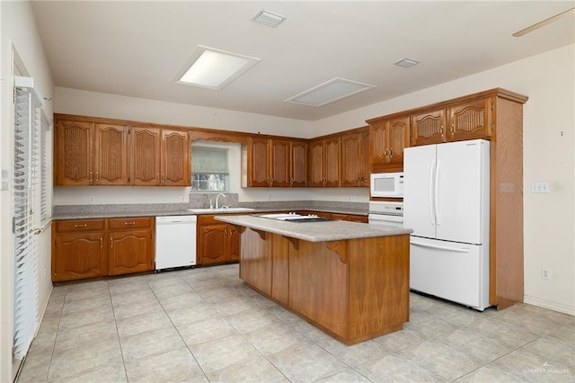 kitchen featuring light tile patterned flooring, white appliances, sink, a kitchen island, and a breakfast bar area