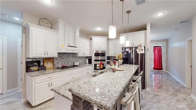 1003 Pear St W, Pharr, TX 78677 - kitchen featuring stainless steel appliances, a breakfast bar, backsplash, under cabinet range hood, and recessed lighting