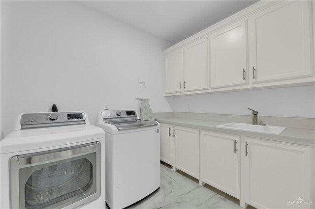 washroom featuring washing machine and dryer, marble finish floor, a sink, and cabinet space