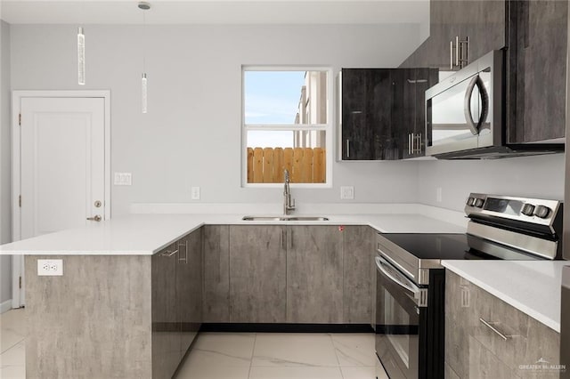 kitchen featuring appliances with stainless steel finishes, sink, hanging light fixtures, dark brown cabinetry, and kitchen peninsula