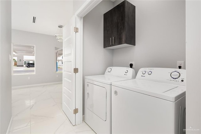 clothes washing area featuring independent washer and dryer and cabinets