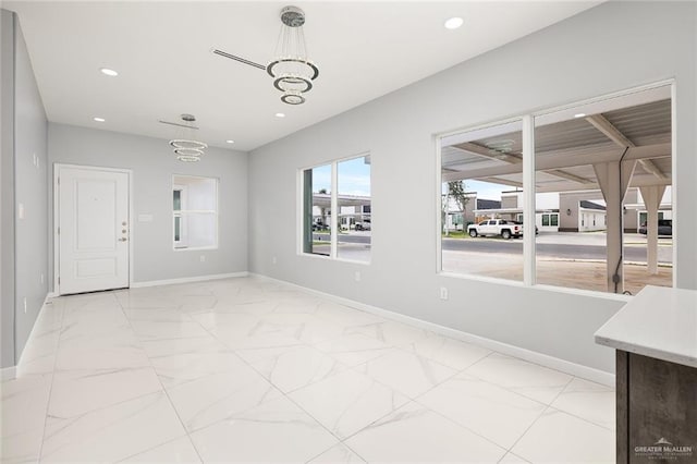 unfurnished dining area featuring a chandelier