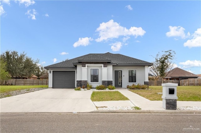 prairie-style home featuring concrete driveway, an attached garage, fence, a front yard, and stucco siding