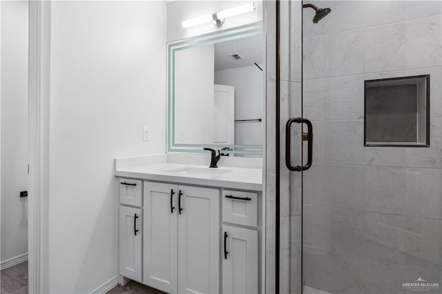 full bath with visible vents, a stall shower, vanity, and baseboards