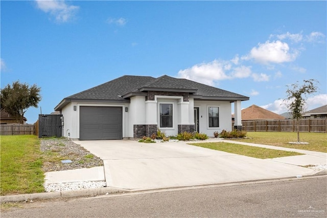 view of front facade with a garage, concrete driveway, roof with shingles, fence, and a front lawn