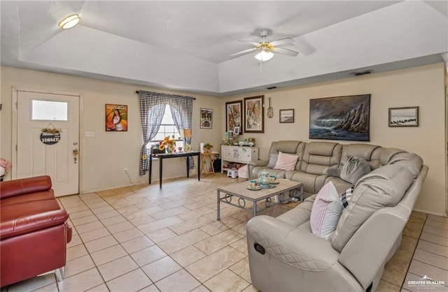 tiled living room featuring ceiling fan and a tray ceiling