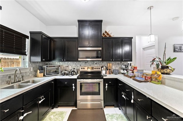 903 W Smith Dr, Pharr, TX 78577 - kitchen featuring a sink, stainless steel appliances, backsplash, light countertops, and dark cabinetry