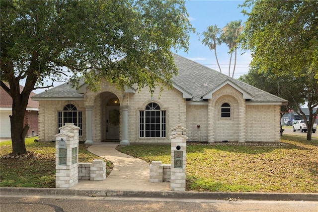 7600 N 23rd Cir, Mcallen, TX 78504 - view of front of home with a shingled roof, brick siding, and a front yard