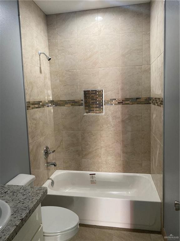 full bathroom featuring tile patterned flooring, vanity, toilet, and tiled shower / bath