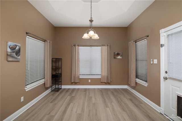 1614 Gabriels Lndg, Harlingen, TX 78550 - unfurnished dining area with light wood-style flooring, a chandelier, and baseboards